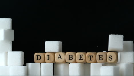 Terrones-De-Azúcar-Y-Dados-Que-Deletrean-Diabetes-Cayendo-En-Fondo-Negro-Sobre-La-Pared-De-Terrones-De-Azúcar