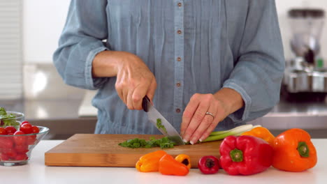 Woman-slicing-spring-onion-with-knife