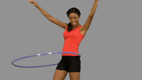 Mujer-Jugando-Con-Un-Hula-hoop-En-Pantalla-Gris.