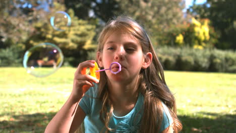 Smiling-young-girl-blowing-into-a-bubble-wand