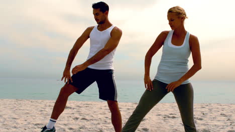 Man-and-woman-doing-pilates-on-beach-together