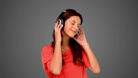 Woman-listening-to-music-on-grey-background