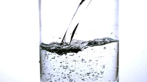 Wasser-Wird-In-Ein-Glas-Auf-Weißem-Hintergrund-Gegossen