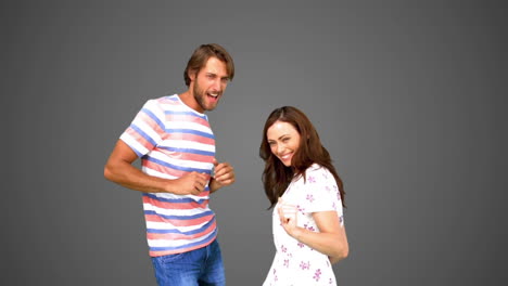 Two-friends-dancing-together-on-grey-background