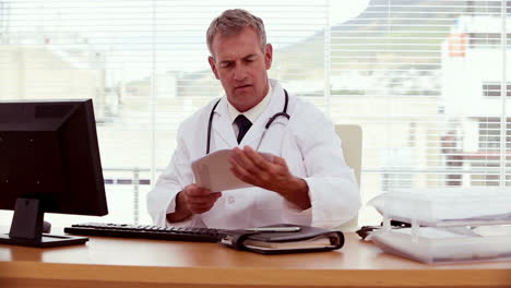 Doctor-searching-document-and-using-his-computer-
