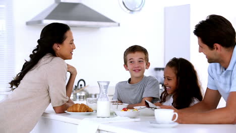 Mother-chatting-to-children-at-family-breakfast
