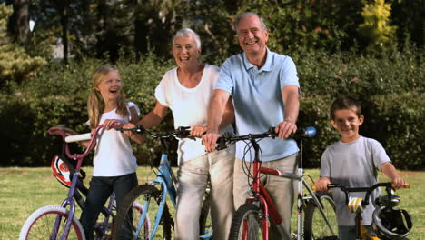 Multigeneration-family-standing-in-a-park-with-their-bicycles-