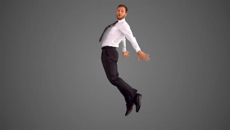 Businessman-jumping-and-stretching-out-on-grey-background