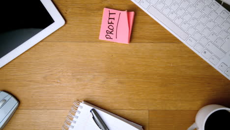 Pink-sticky-notes-with-profit-written-in-bold-falling-on-office-desk