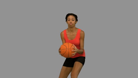 Pretty-woman-catching-and-throwing-a-basketball-on-grey-screen