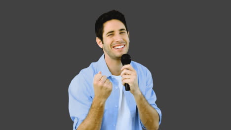 Man-singing-into-microphone-with-emotion-on-grey-background