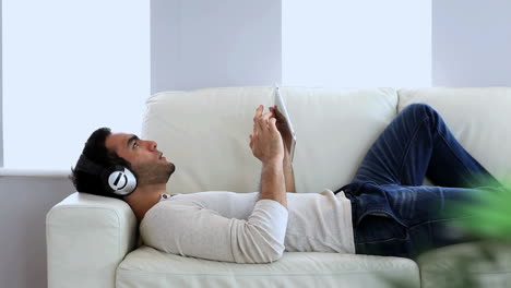 Man-listening-to-music-with-his-tablet-pc