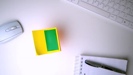 Yellow-post-it-with-chroma-key-falling-on-office-desk