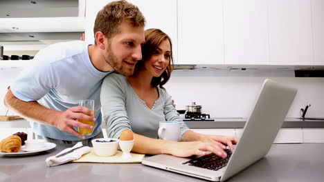 Woman-showing-her-partner-something-on-laptop