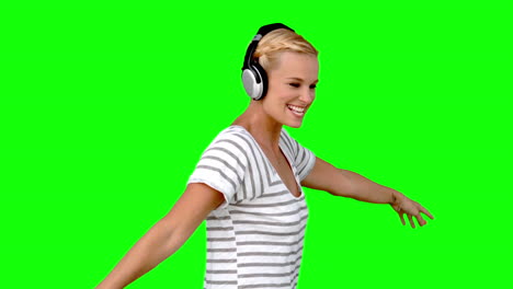 Young-woman-listening-to-music-on-green-screen