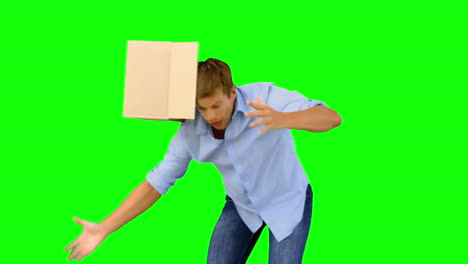 Clumsy-man-dropping-boxes-down-on-green-screen