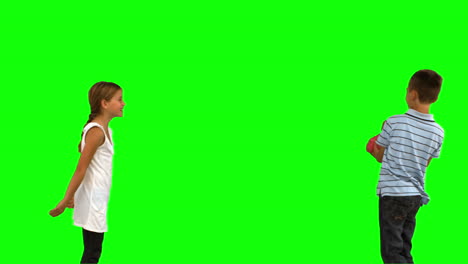 Siblings-playing-with-a-heart-shaped-cushion-on-green-screen