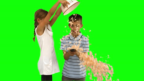 Sister-pouring-popcorn-on-brothers-head-on-green-screen