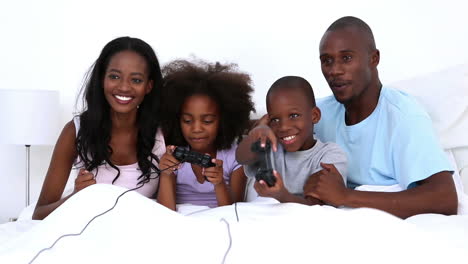 Family-playing-video-games-on-bed