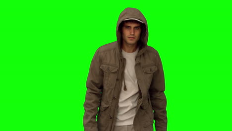 Man-with-a-coat-walking-toward-camera-on-green-screen