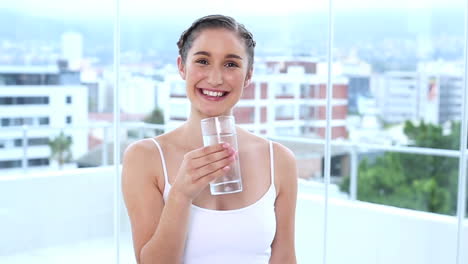 Smiling-young-woman-drinking-water