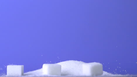 Terrones-De-Azúcar-Cayendo-En-Un-Montón-De-Azúcar-Sobre-Fondo-Púrpura