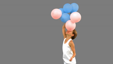 Kleines-Mädchen-Spielt-Mit-Luftballons-Auf-Grauem-Bildschirm
