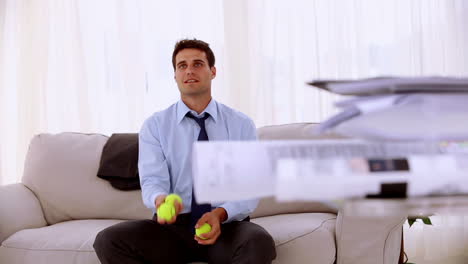 Happy-businessman-juggling-with-tennis-ball-