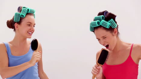 Freunde-Mit-Lockenwicklern-Singen-In-Ihre-Haarbürsten