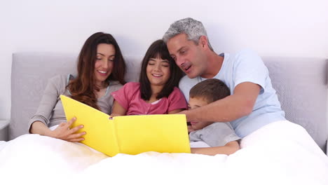 Family-reading-a-storybook-in-the-bed