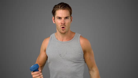 Man-exercising-with-dumbbell-on-grey-background