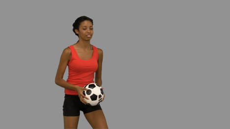 Woman-juggling-a-football-on-grey-screen