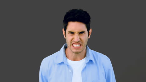 Man-growling-at-camera-angrily-on-grey-background