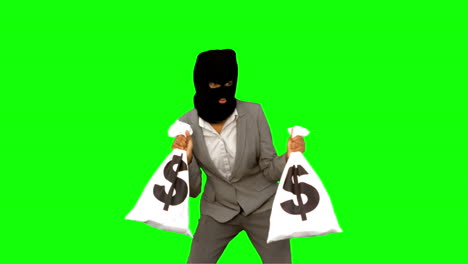 Burglar-wearing-balaclava-and-holding-money-bags-on-green-screen