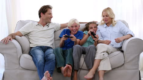 Familia-Feliz-Jugando-Videojuegos-En-Casa