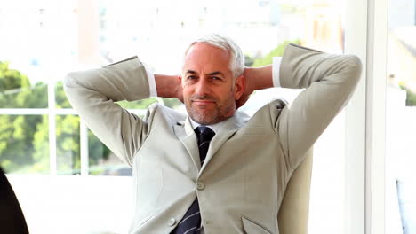 Confident-businessman-relaxing-on-his-chair