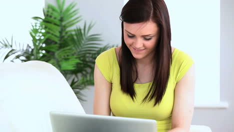 Brunette-woman-typing-on-her-laptop