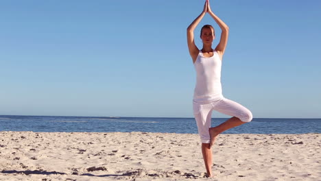 Woman-practicing-yoga-on-the-beach