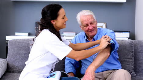 Hauskrankenschwester-überprüft-Den-Blutdruck-Ihrer-Patientin