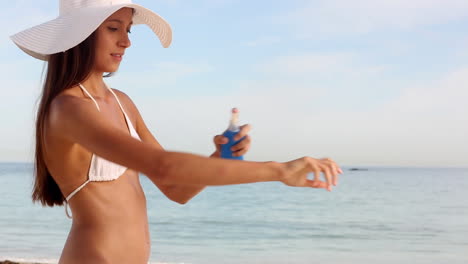 Woman-with-hat-applying-sunscreen-protection