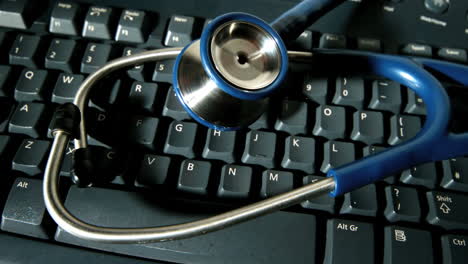 Blue-stethoscope-falling-onto-computer-keyboard-and-bouncing