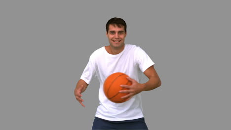 Man-playing-and-dribbling-with-a-basketball-on-grey-screen