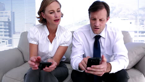 Businesswoman-showing-colleague-how-to-work-smartphone