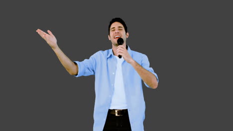 Mann-Singt-Ins-Mikrofon-Auf-Grauem-Hintergrund