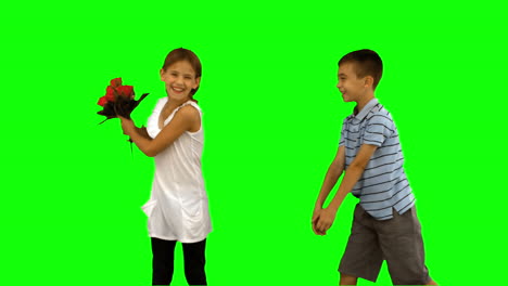 Junge-Bietet-Einem-Kleinen-Mädchen-Auf-Einem-Greenscreen-Einen-Blumenstrauß-An