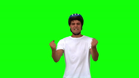 Man-wearing-a-helmet-holding-his-head-on-green-screen