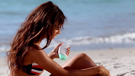 Woman-applying-sun-cream-on-the-beach