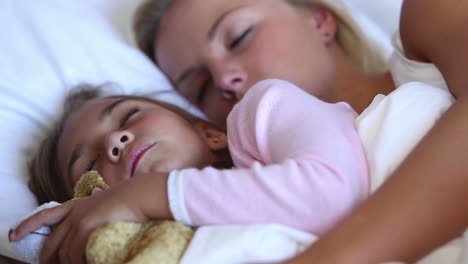 Mother-and-daughter-cuddling-in-bed