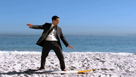 Businessman-balancing-on-surfboard-on-the-beach
