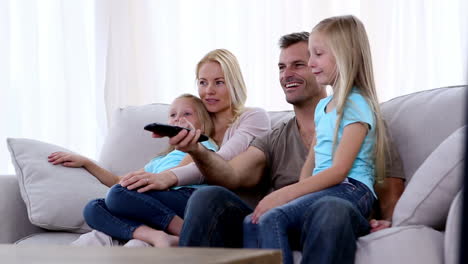 Family-watching-television-on-sofa